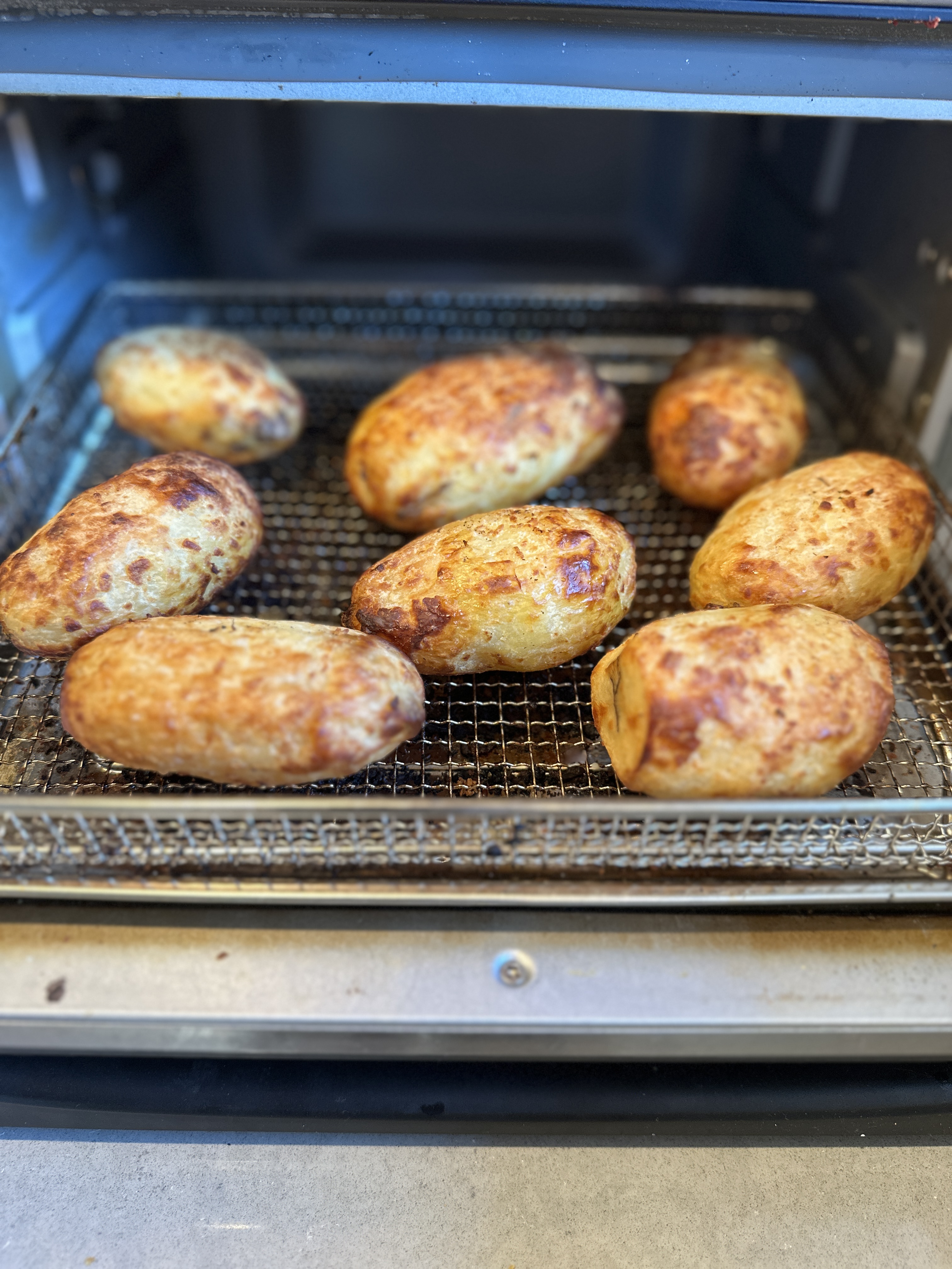 Golden-brown air-fried potatoes fresh off the rack