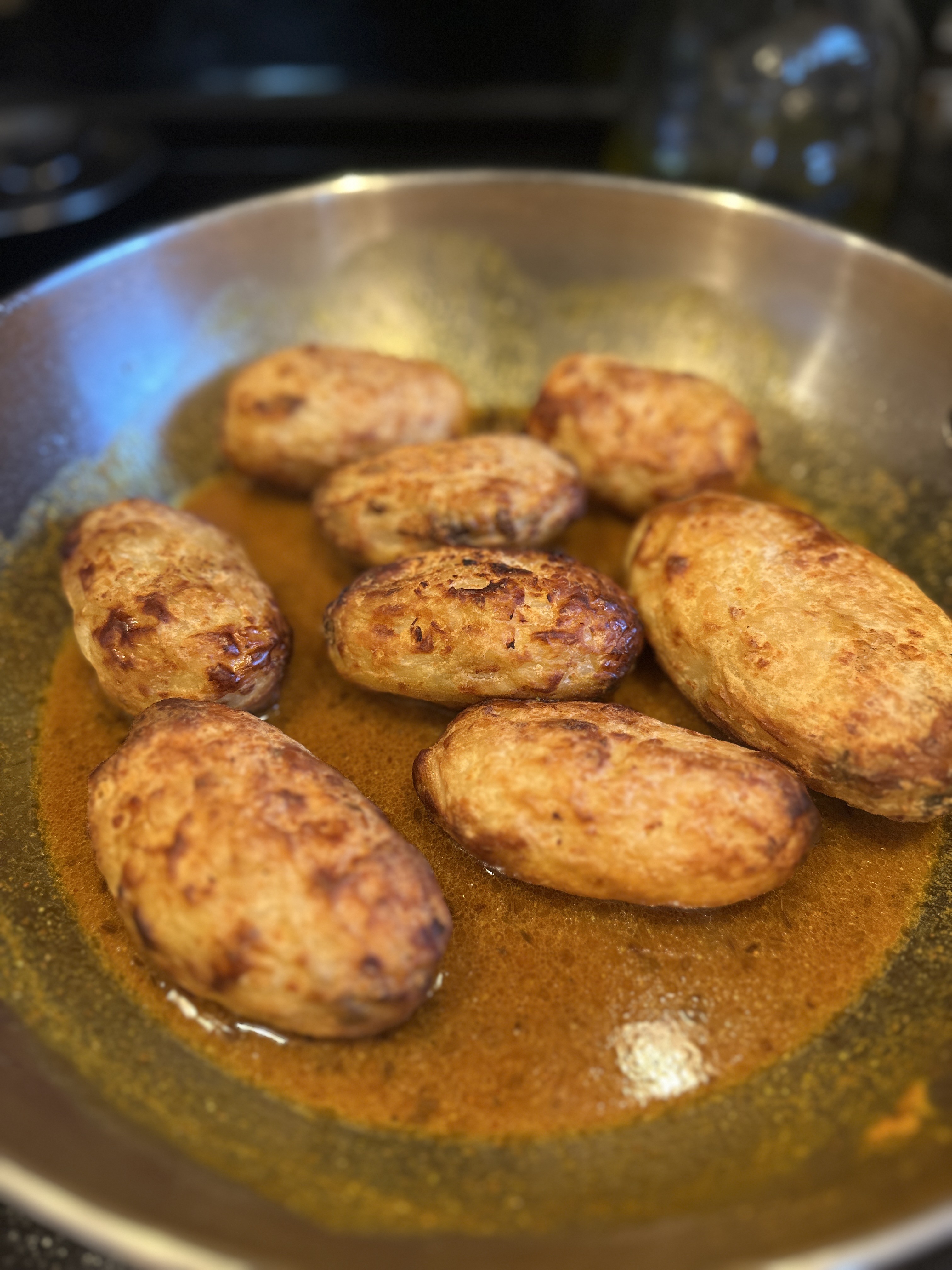 Air-fried potatoes placed into the sauce, not yet coated